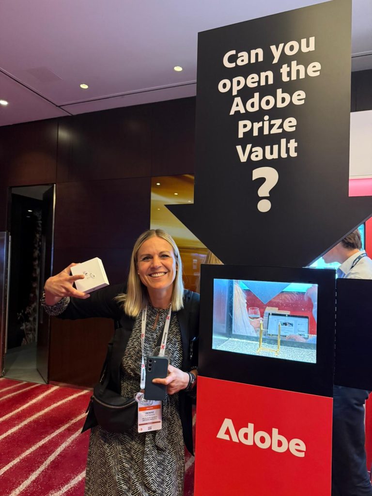 Guest standing next to our Prize Vault at an Adobe event, celebrating their win.