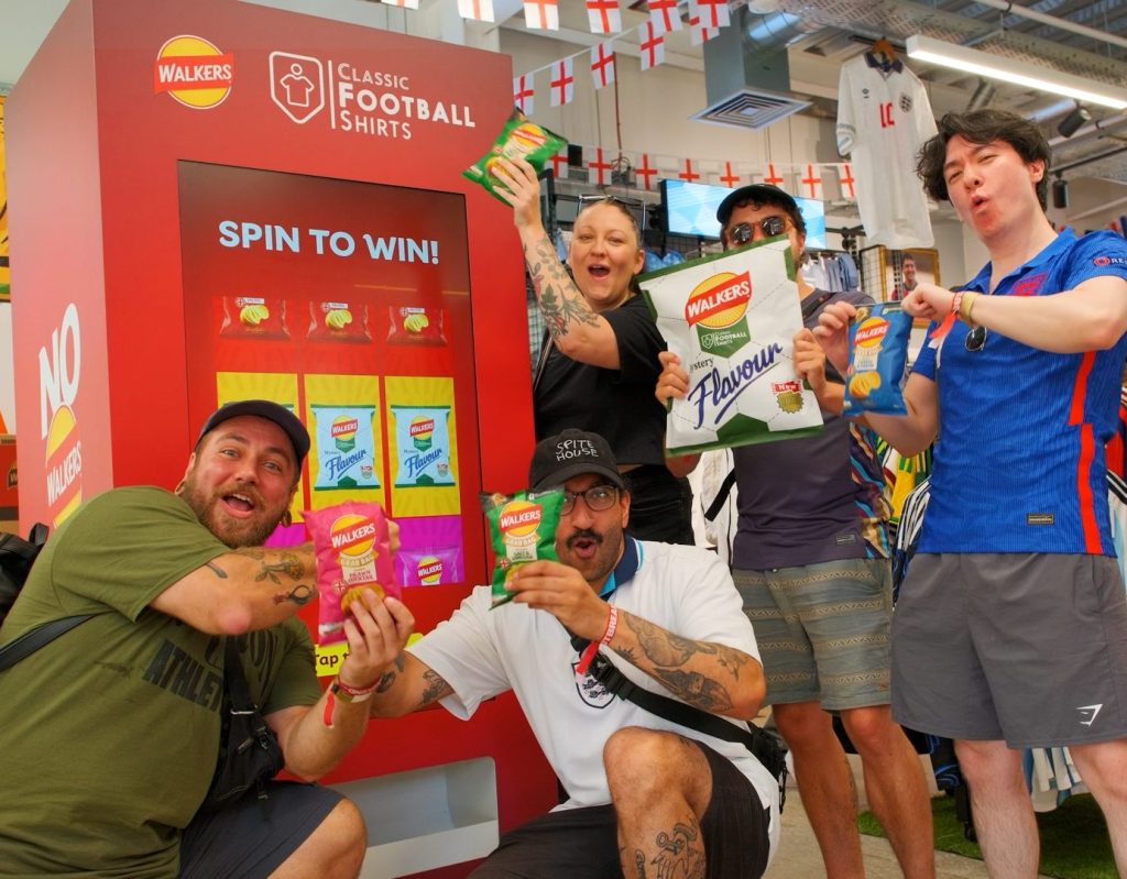 Event guests posing with prizes in front of prize giveaway vending machine