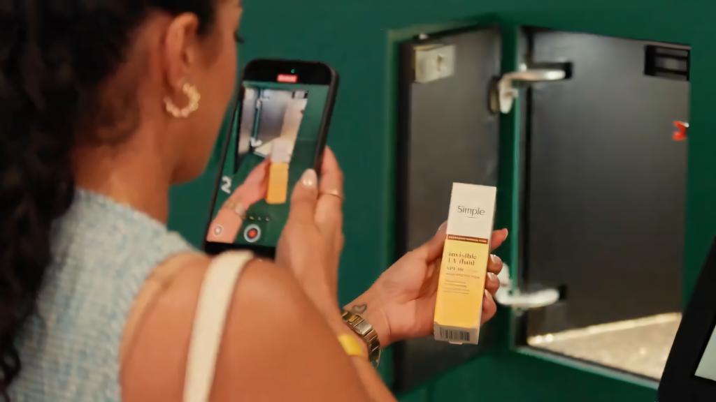 Winner at the Simple Beauty event taking a photo of her prize from the Noonah Prize Wall.