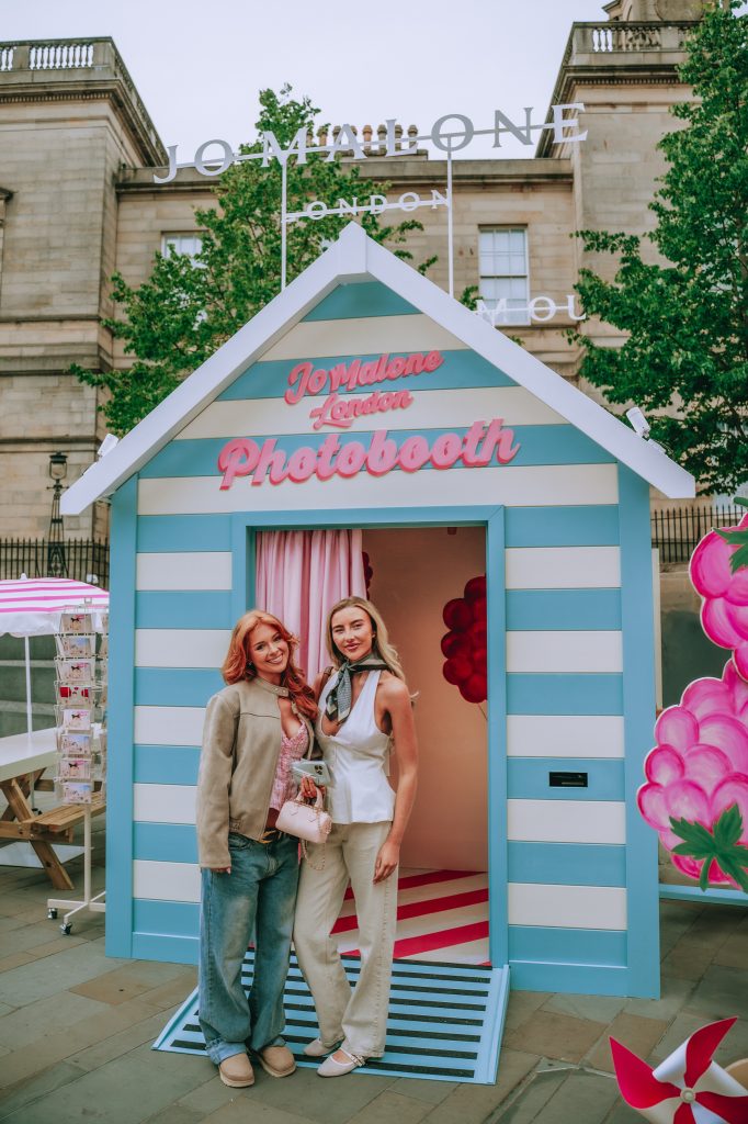 two influencers stood outside the photo booth