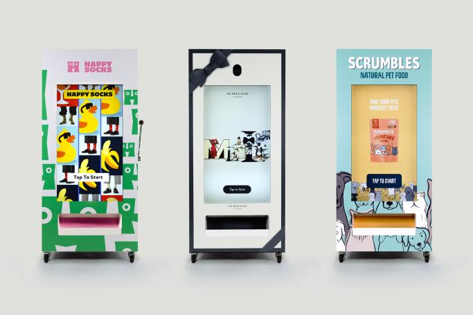 Three smart vending machines for events displayed side by side, showing Jackpot mode with Happy Socks branding, Photo and Video mode with Jo Malone branding, and Q&A mode with Scrumbles branding.