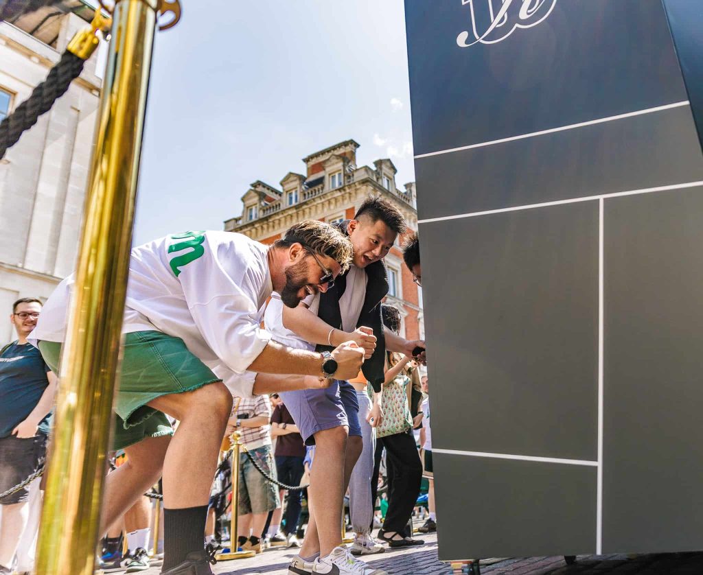 2 men celebrating winning a prize from branded vending machine at Kith and Kin brand event