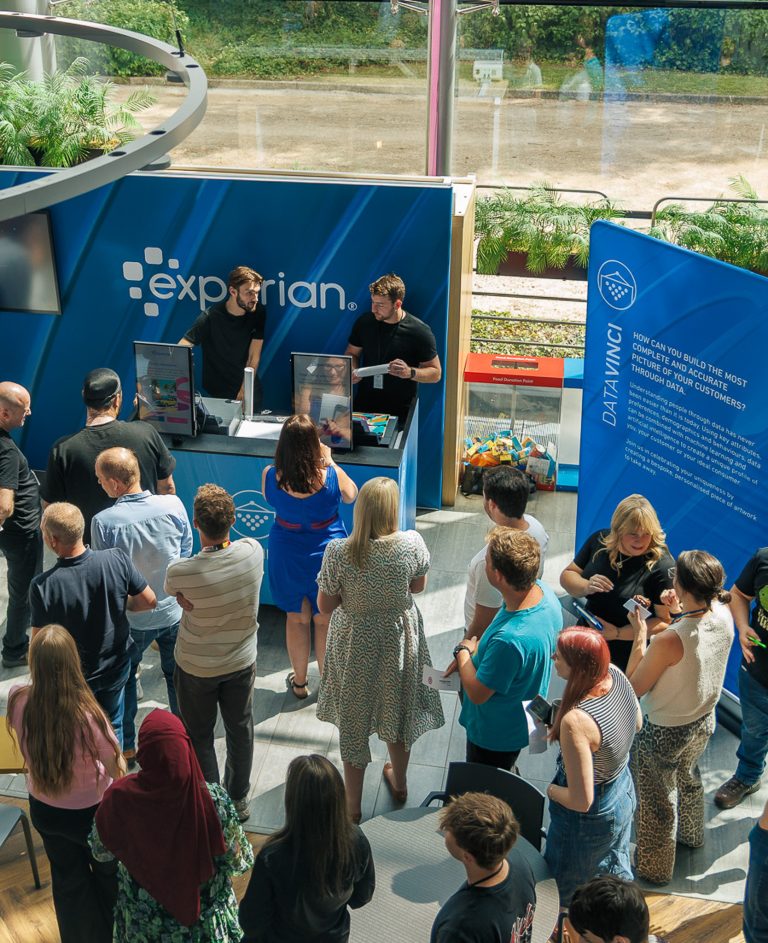 Large crowd engaging with AI live event printing, driving footfall at a trade show stand.