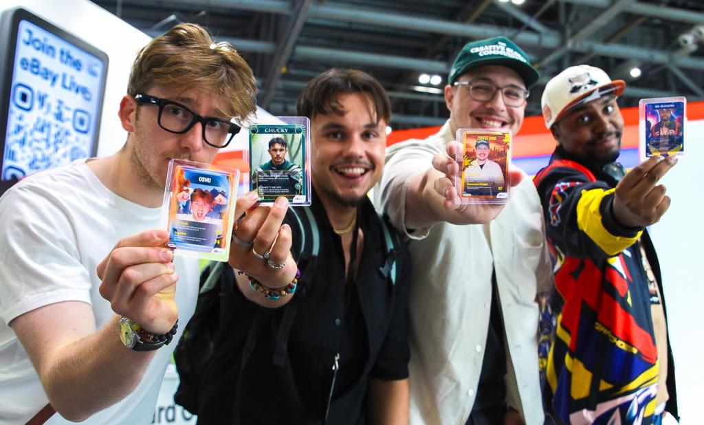 4 people holding their AI Trading Cards and smiling at Comicon