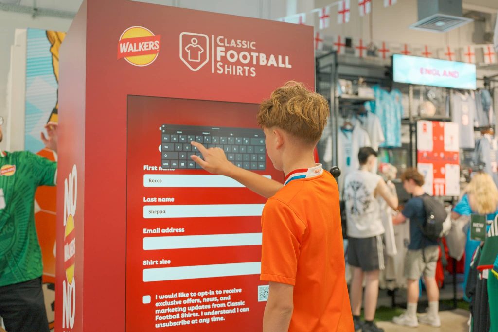 boy typing data into walkers branded vending machine